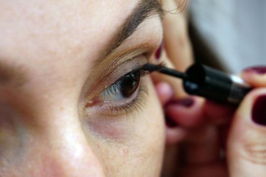 Woman making eye make up close up view