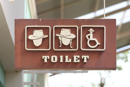 toilet sign hanging on wall  with roof background