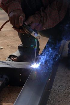 close up hand of worker welding metal
