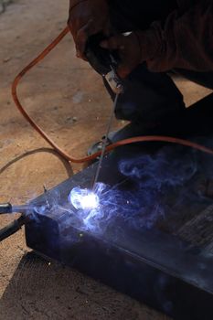 close up hand of worker welding metal