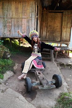Traditionally dressed Mhong hill tribe woman at the wooden cottage