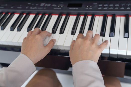 hands of a young woman playing piano