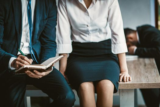 Brainstorming Of Two Colleagues, Close Up Of Knees Of Caucasian Man And Woman Sitting On Office Table While Making Notes In Notebook, Toned Image