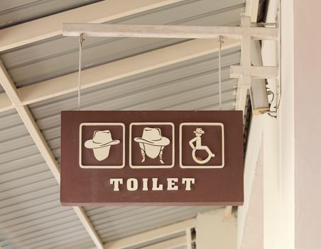 toilet sign hanging on wall  with roof background