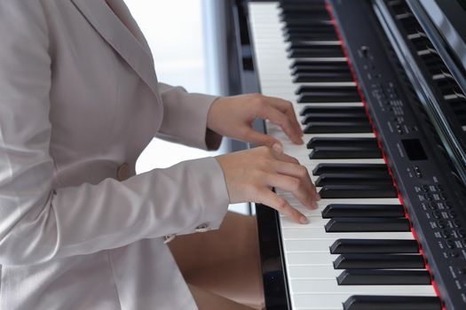 hands of a young woman playing piano