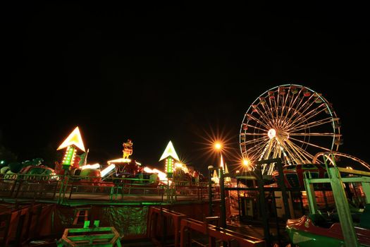 Amusement park at night with ferris wheel