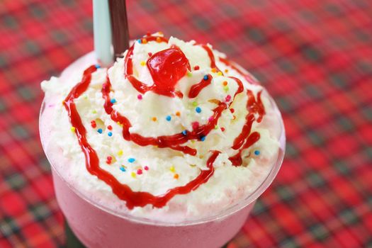 close-up strawberry milkshake with cream in a cafe