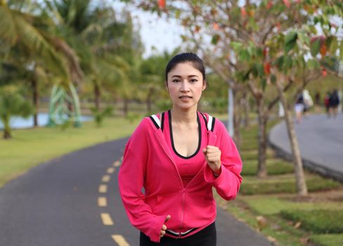 young healthy asian woman running in the park