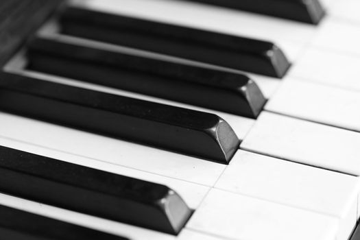 Close-up of black and white piano keys and wood grain 