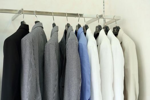 Row of men's suit jackets hanging in a retail shop