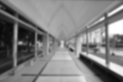 blurred image of empty corridor between garden and building (monochrome background)