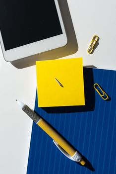 Note With Important Message On Desk With Pen, Mobile Phone And Paperclips.