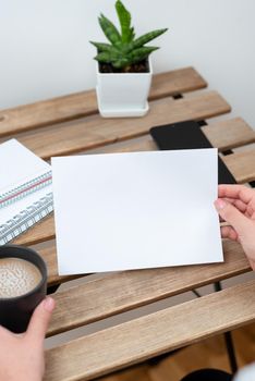 Sitting Businesswoman Holding Important Message On Paper On Table.