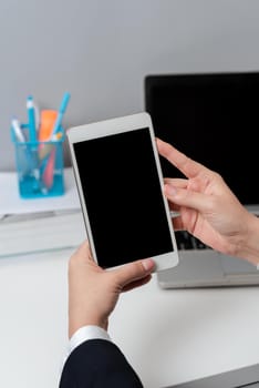 Sitting Businesswoman Holding Mobile Phone With Important Messages.