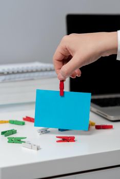 Woman Holding Important Idea On Note Over Desk With Lap Top And Paperclips.