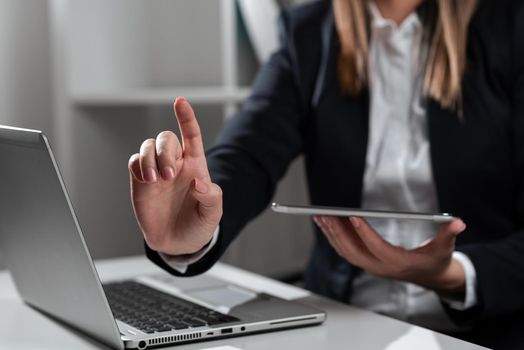 Woman Holding Tablet In One Hand And Pointing On News With One Finger.