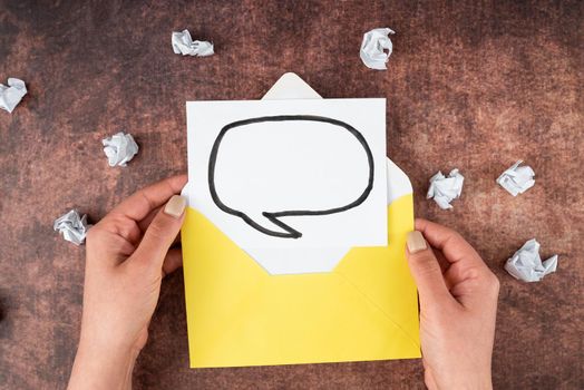 Hands Of Woman Holding Thought Bubble Sheet With Envelope On Table.