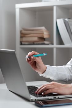 Woman Typing Updates On Lap Top And Pointing New Ideas With Pen.