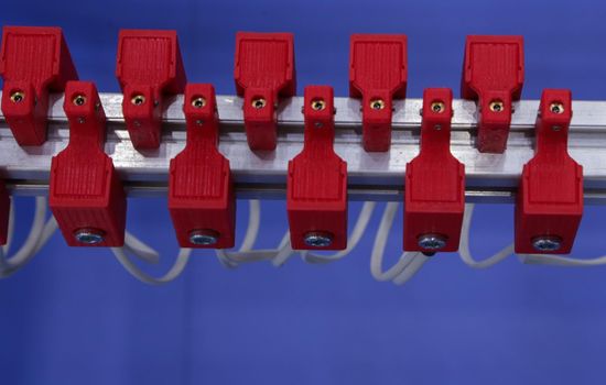 Red wire contacts on a blue background. Installation electrical cables.