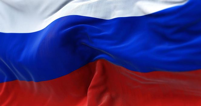 Close-up view of the Russian national flag waving in the wind. Russia is a transcontinental country spanning Eastern Europe and Northern Asia