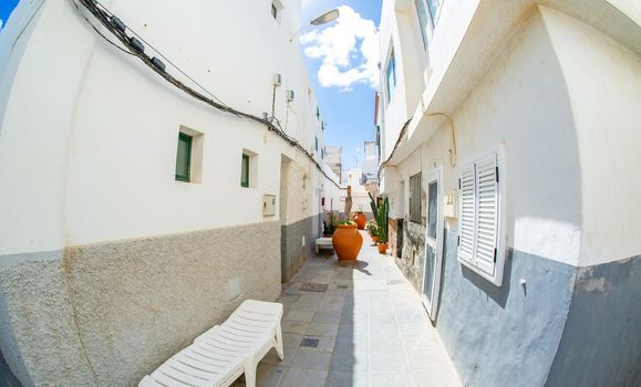 Narrow streets adorned with flowers on balconies and very large flower pots in Ojos de Garza Canary Island