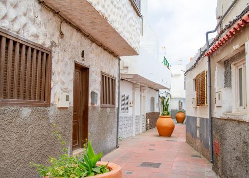 Narrow streets adorned with flowers on balconies and very large flower pots in Ojos de Garza Canary Island