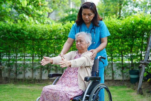 Asian elderly woman disability patient exercise on wheelchair with doctor in park, medical concept.