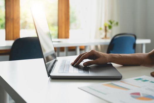 Close-up of female hands using laptop at office, woman's hands typing on laptop keyboard in interior,, side view of businesswoman using computer in cafe.