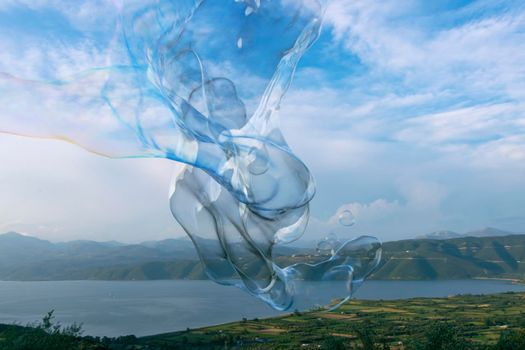 Huge iridescent, bubble contorting in size and shape over the picturesque Lake Trichonida, the largest natural lake in Greece.
