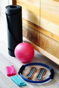 Pilates set with mat stretch ball on wooden background