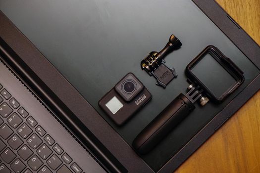 16 May 2019 Eskisehir, Turkey. Gopro 7 black assorted accessories and laptop on wooden background