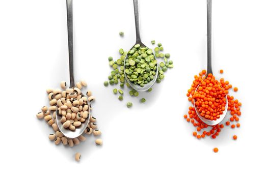 A set of different cereals. Ancient grain food green peas dried beans black eyes on spoons on white background. Top view and flat lay