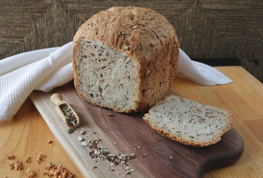 Sliced rye bread on cutting board. Whole grain rye bread with seeds. loaf of homemade whole grain bread and a cut off slice of bread. Mixture of seeds and whole grains. Healthy eating conception