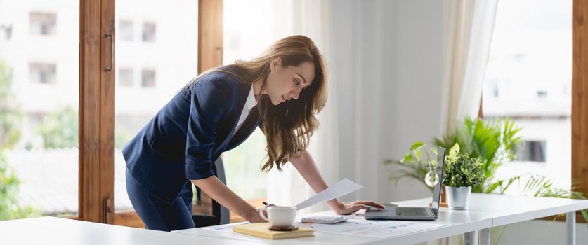 Portrait confident businesswoman asian working at laptop for financial chart report at office