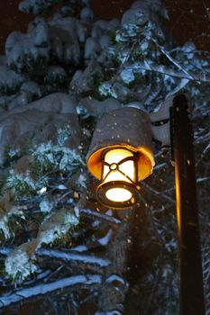 Street lamp in the snowy night close up
