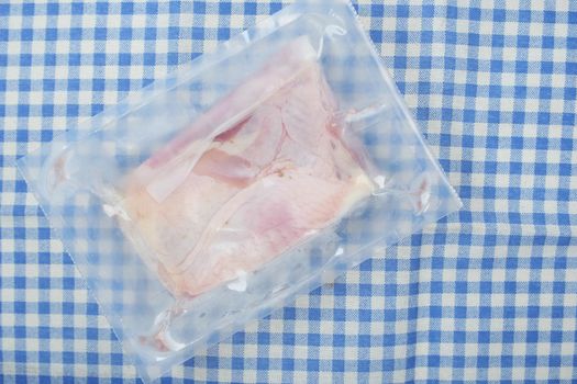 raw chicken breast in a packet on table .