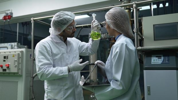 Two scientist in professional uniform working in laboratory for chemical and biomedical experiment