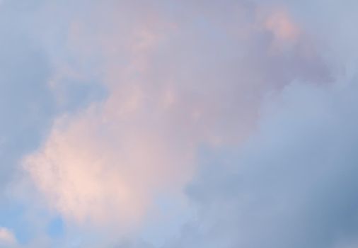 Background of blue sky with pale pink clouds at sunset