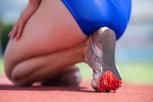 Close-up of female legs. The runner in the stadium is ready for the race