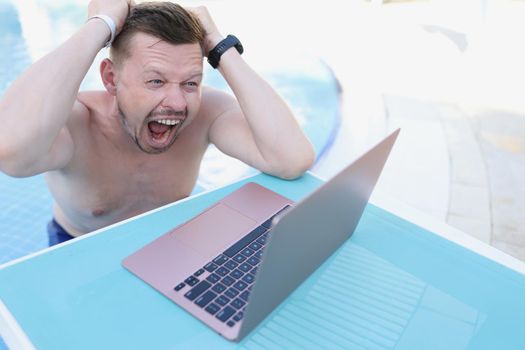 Portrait of touch head with hands, late with work project, failed deadline, panic and stress. Laptop online conversation with boss. Go nuts, upset concept