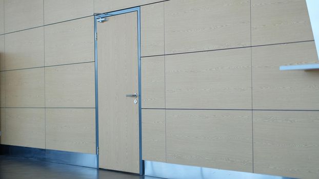 Light brown door and wall in building of airport station or business center. Stylish fashionable loft design in business centers