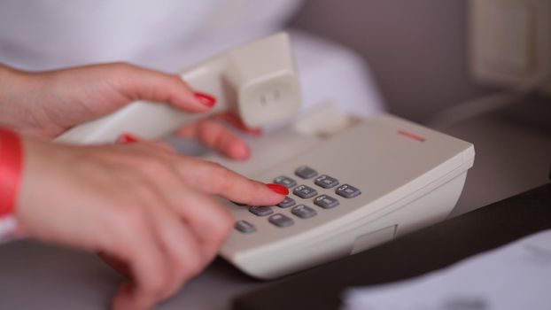 Business woman dialing phone number in hotel room. Hotel services and staff call concept