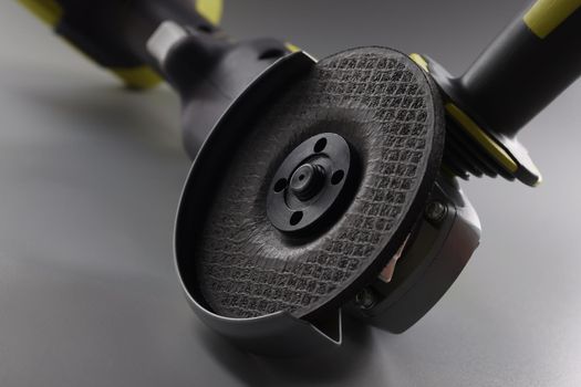 Close-up of grinder instrument for metal works, electrical saw on grey background. Circular saw equipment for construction works. Carpentry, handy concept