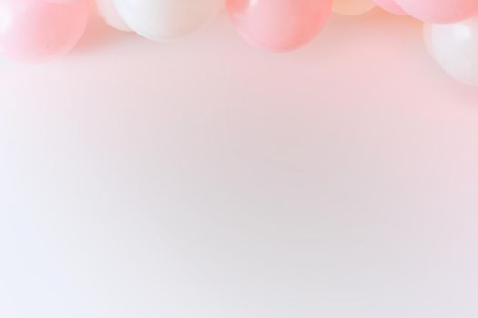 Light pink grafitti background with white and pink balloons.
