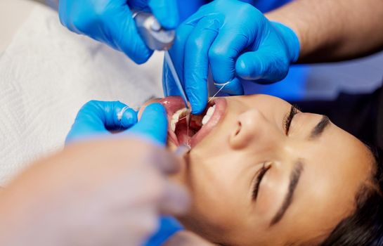 Caring for you, caring for your smile. a young woman having a dental procedure performed on her