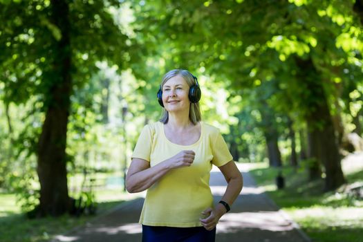 Senior gray-haired woman jogging in a summer park