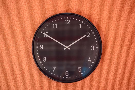 Classic black and white analog clock on red background at One o'clock with copy space.