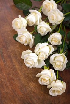 bouquet of white rose with green leaves on a wooden