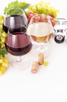 glasses of red and white wine and ripe grapes on table