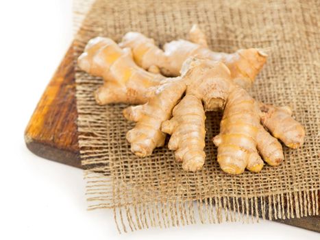 Whole ginger roots on dark wooden background